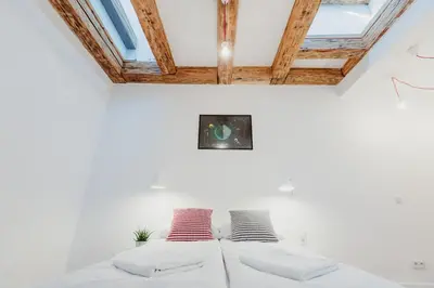 a white room with two pillows on a bed at City Center Apartment by CityBeat in Kraków