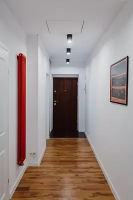 a hallway with a door and a wooden floor at City Center Apartment by CityBeat in Kraków