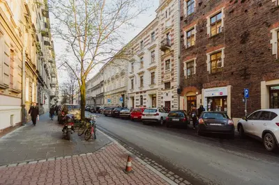 a city street with parked cars and buildings at City Center Apartment by CityBeat in Kraków