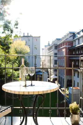 a table with two wine glasses on a balcony at Aparthotel BC 29 Residence in Kraków