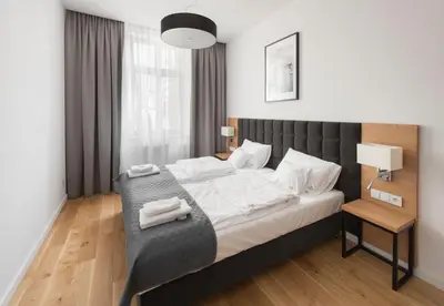 a bedroom with a large bed with a black headboard at Aparthotel BC 29 Residence in Kraków