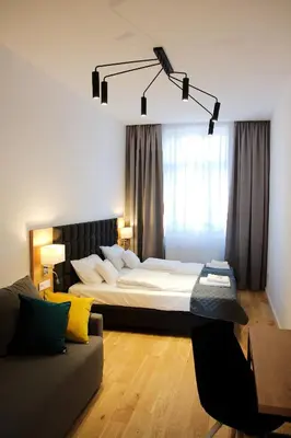 a bedroom with a large bed and a couch at Aparthotel BC 29 Residence in Kraków