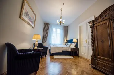 a bedroom with a bed and a chair and a table at MJZ Apartments Old Town Krakow in Kraków