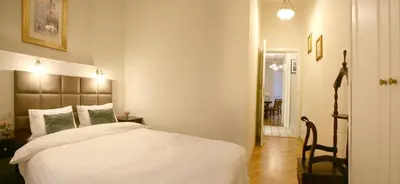 a bedroom with a white bed and a chair at MJZ Apartments Old Town Krakow in Kraków