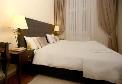 a bedroom with a large bed with a lamp and a table at MJZ Apartments Old Town Krakow in Kraków