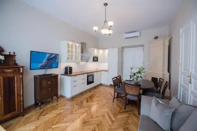 a kitchen and dining room with a table and a television at MJZ Apartments Old Town Krakow in Kraków