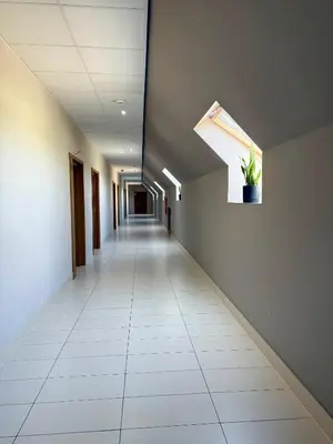 an empty hallway in an office building with a window at Podhalanin noclegi in Wadowice
