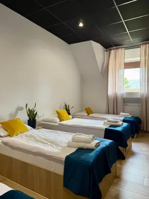 a row of beds in a room with blue seats at Podhalanin noclegi in Wadowice