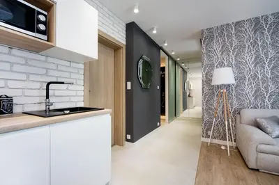 a kitchen with a sink and a living room at LEMIR Apartments Wawrzyńca 21 in Kraków
