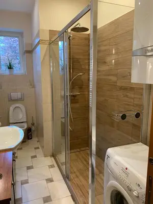 a bathroom with a shower and a washing machine at Excellent apartment with balcony in Kraków