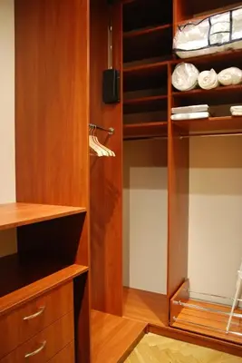a walk in closet with wooden cabinets and shelves at Excellent apartment with balcony in Kraków