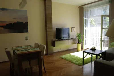 a living room with a dining room table and a television at Excellent apartment with balcony in Kraków
