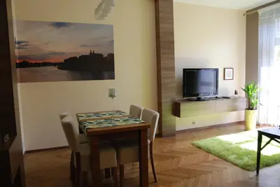 a dining room with a table and a television at Excellent apartment with balcony in Kraków