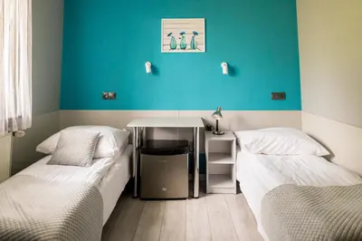 a room with two beds and a table in it at Eko Hotel Na Wierzynka & Park Pinokia in Wieliczka
