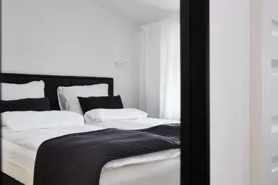 a bed with black and white sheets and pillows at St Agnes Apartments Attic in Kraków