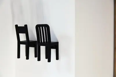 a black chair is hanging on a wall at St Agnes Apartments Attic in Kraków