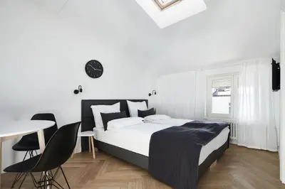 a bedroom with a bed and a table and chairs at St Agnes Apartments Attic in Kraków