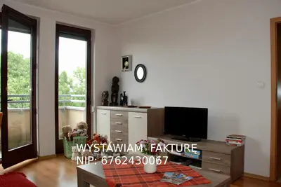 a living room with a tv and a table at Apartment AMUR in Kraków