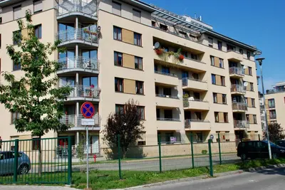 an apartment building with balconies and a fence at Apartment AMUR in Kraków