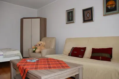 a living room with a couch and a teddy bear at Apartment AMUR in Kraków