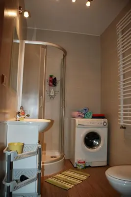 a bathroom with a washing machine and a sink at Apartment AMUR in Kraków