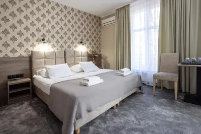 a hotel room with two beds with towels on them at Hotel Maksymilian in Kraków
