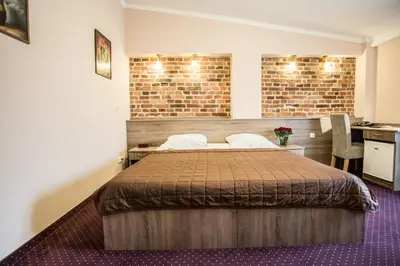 a hotel room with two beds in a room at Hotel Maksymilian in Kraków