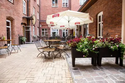 a restaurant with tables and chairs and a brick wall at Hotel Maksymilian in Kraków
