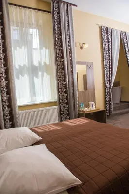 a hotel room with two beds and a table at Hotel Maksymilian in Kraków