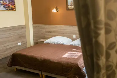 a hotel room with two beds and a brick wall at Hotel Maksymilian in Kraków