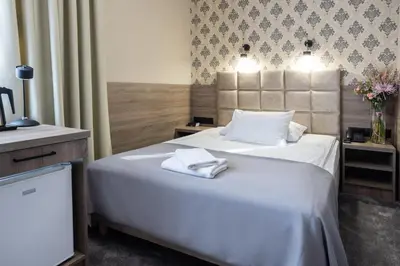 a hotel room with two beds with towels on them at Hotel Maksymilian in Kraków