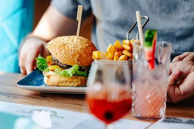 a sandwich and french fries on a plate on a table at Villa Astra - Apartments & Restaurant in Oświęcim