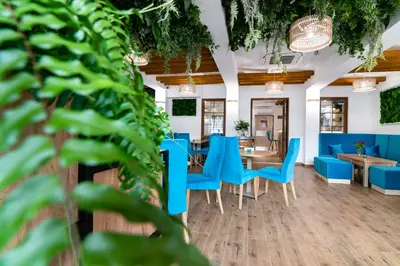 a dining room with blue chairs and tables at Villa Astra - Apartments & Restaurant in Oświęcim