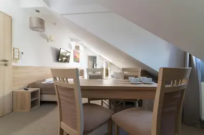 a dining room with a table and two chairs at Villa Astra - Apartments & Restaurant in Oświęcim