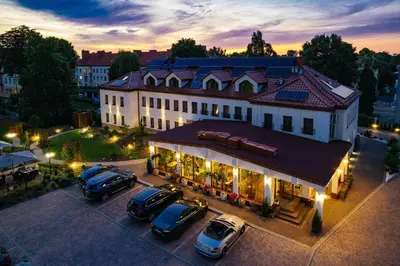 an overhead view of a building with cars parked in a parking lot at Villa Astra - Apartments & Restaurant in Oświęcim