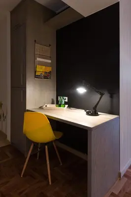 a desk with a yellow chair and a lamp at Sunflower Apartment in Kraków