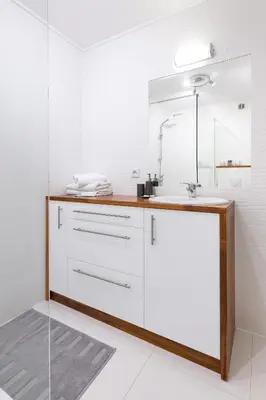 a white bathroom with a sink and a mirror at Sunflower Apartment in Kraków