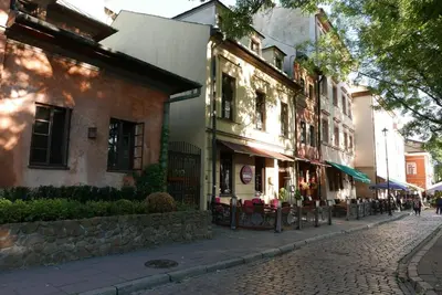 a cobblestone street next to a building with tables at Sunflower Apartment in Kraków
