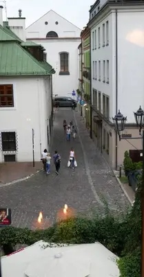 a group of people walking down a street with buildings at Sunflower Apartment in Kraków