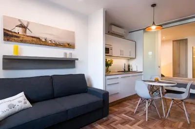 a living room with a couch and a table and a kitchen at Sunflower Apartment in Kraków