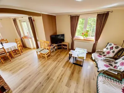 a living room with a fireplace and a brick wall at Zawoja Domek 1895 - Sauna i Bania in Zawoja