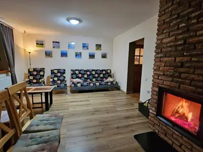 a living room with a table and chairs and a fireplace at Zawoja Domek 1895 - Sauna i Bania in Zawoja