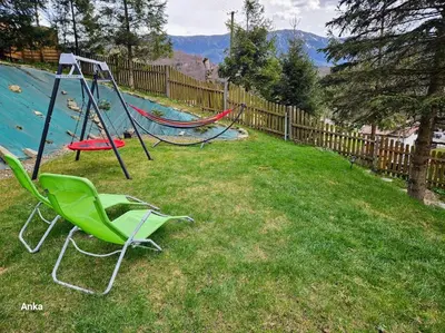 a playground with two swings in a yard at Zawoja Domek 1895 - Sauna i Bania in Zawoja
