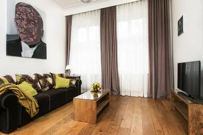 a living room with a couch and a tv at Old Town Brigue Apartment by Otium in Kraków