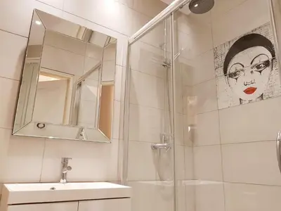 a bathroom with a shower and a sink and a mirror at Old Town Brigue Apartment by Otium in Kraków