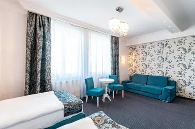 a hotel room with a bed and a couch and a table at Margerita in Modlnica