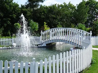 a white bridge over a pond with a fountain at Margerita in Modlnica