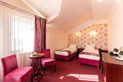 a hotel room with two beds and a desk at Margerita in Modlnica