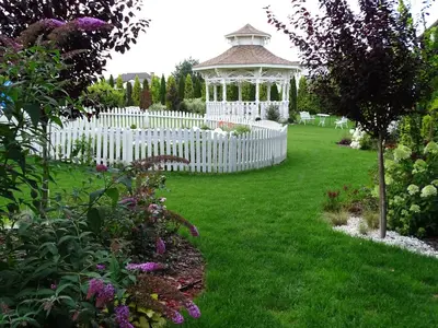 a white fence and a gazebo in a yard at Margerita in Modlnica