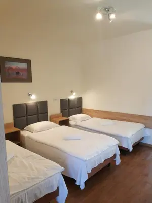 a room with three beds in a room at Hotel Górsko in Wieliczka